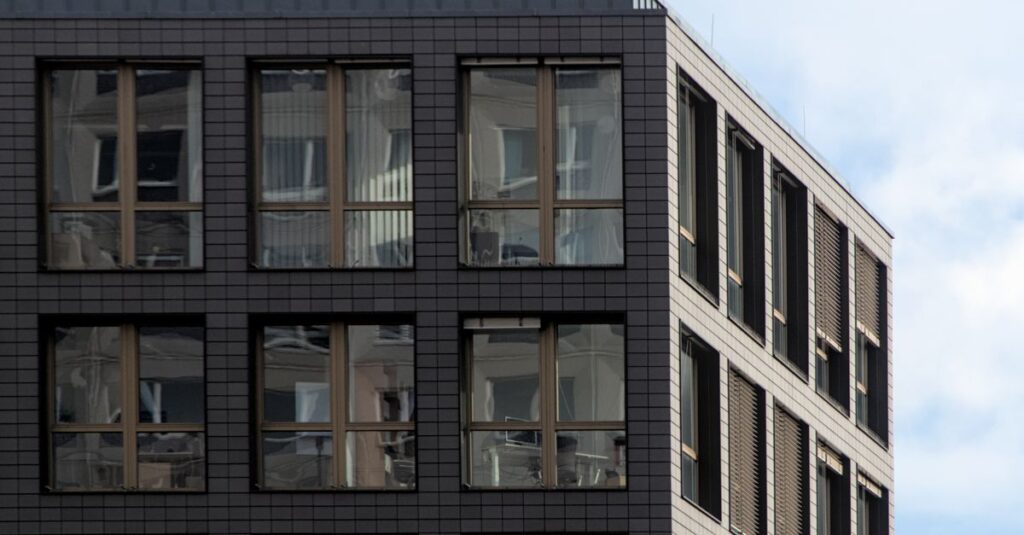 Corner view of a modern office building in Berlin with glass windows and a clear sky.